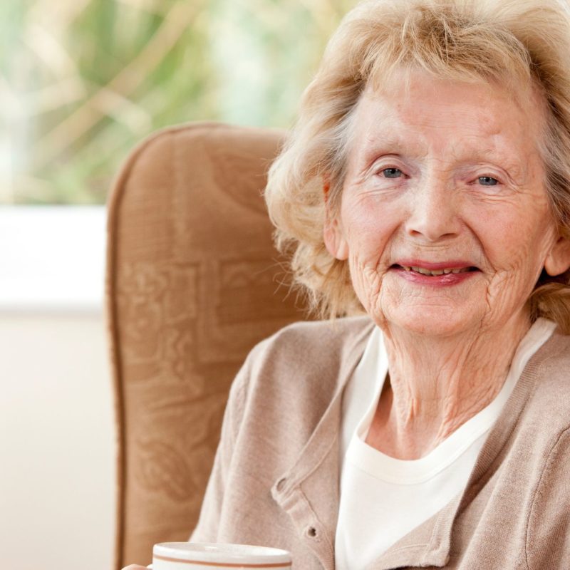 Elderly person wearing Eila Connect's fall detection device for enhanced safety.